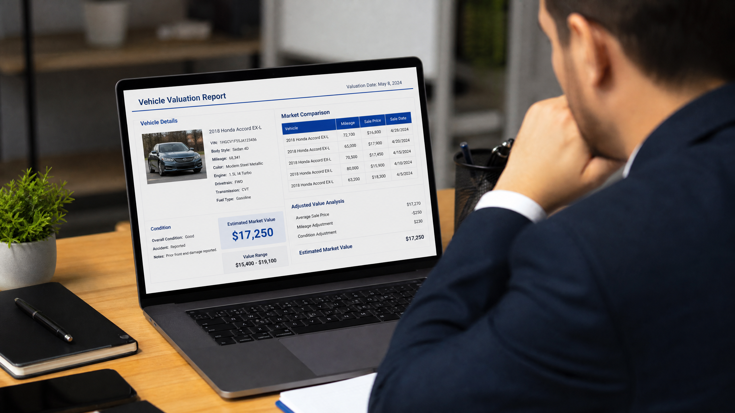 Person reviewing a Liberty Mutual total loss valuation report on a laptop, examining vehicle details and market comparisons